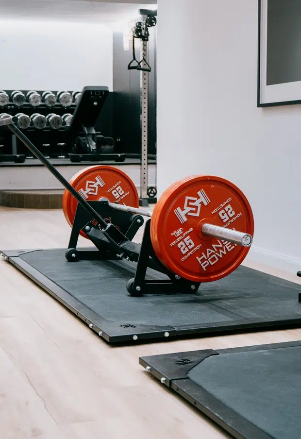 Homme soulevant une barre à disques en salle de sport